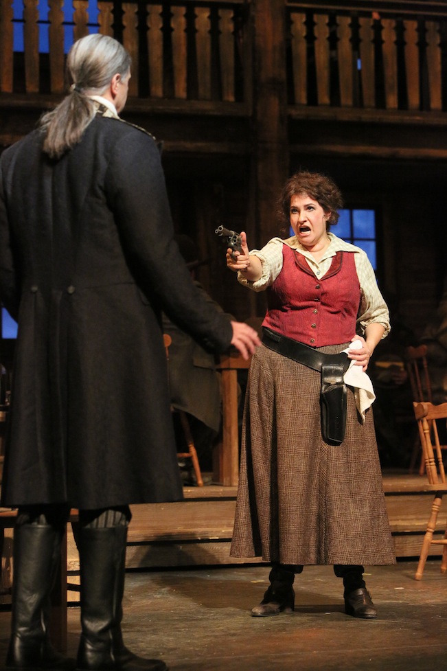 Claire Rutter (right) as Minnie points a gun at Sheriff Jack Rance (played by Greer Grimsley). Photo by Michal Daniel
