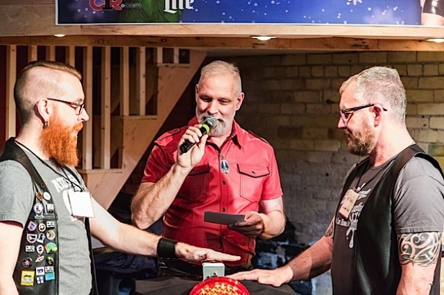 As host/emcee David Coral (center) reads a question, Andrew Bertke (left) of the Atons of Minneapolis faces off at the buzzer with Randy Ingram-Lile (right) of Impawsters. Photo by Andrew Bertke.