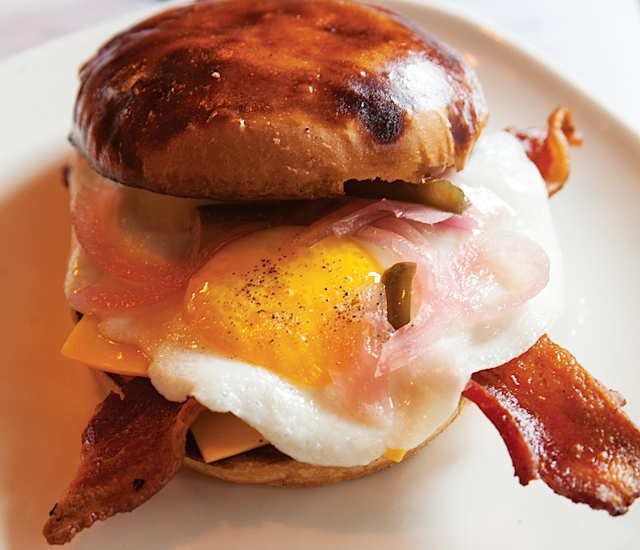 A soon-to-be-famous fried egg sandwich of bacon, egg, cheese, pickled onions, and harissa mayo on a Saint Agnes Baking Co. milk bun.