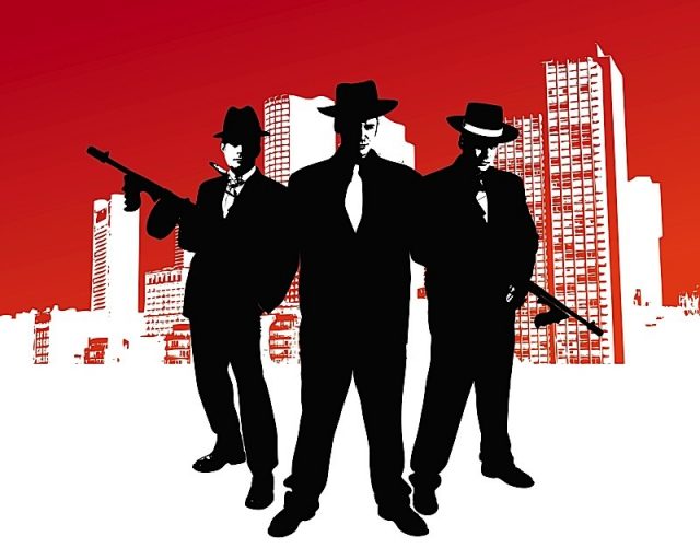 Mafia Boss With Machine Gun Stands In Front Of Skyline Of A City With Design Elements In The Backgro Photo courtesy of BigStock/Sengers