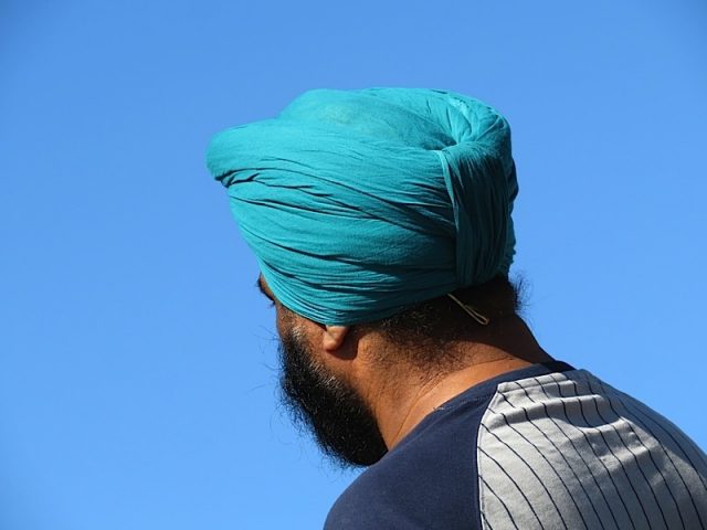 Bearded Indian Sikh In A Cyan Turban On A Background Of Clear Blue Sky, Rear View. Man Wearing Turba Photo courtesy of BigStock/Elkov