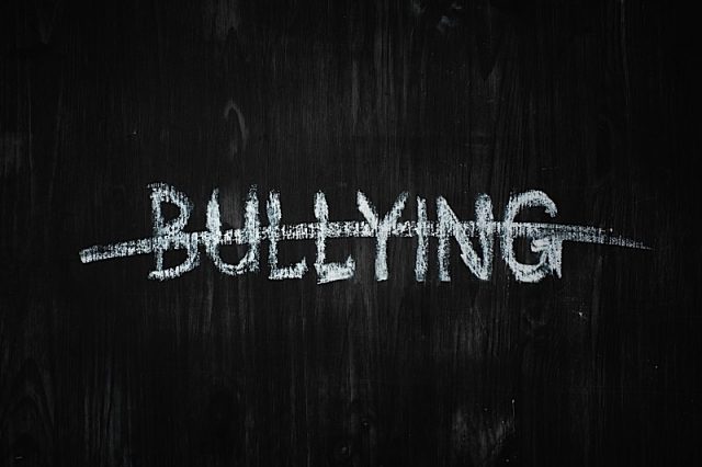 Bullying Word Crossed Out On Black Wood Background. Sign, Concept Of Dealing With Behaviour Social I Photo courtesy of BigStock/photoboyko