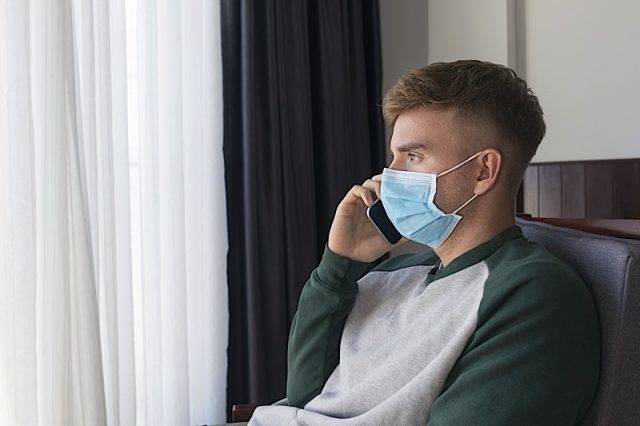 Sad Guy, Young Man Isolated, Stay At Home Calling, Talking On Cell Phone In Protective Sterile Medic Photo courtesy of BigStock/Dorieugene