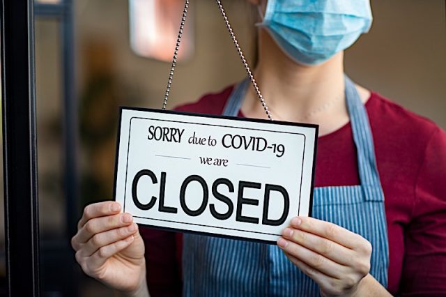 Businesswoman closing her business activity due to covid-19 lockdown. Owner with surgical mask close Photo courtesy of BigStock/Rido81