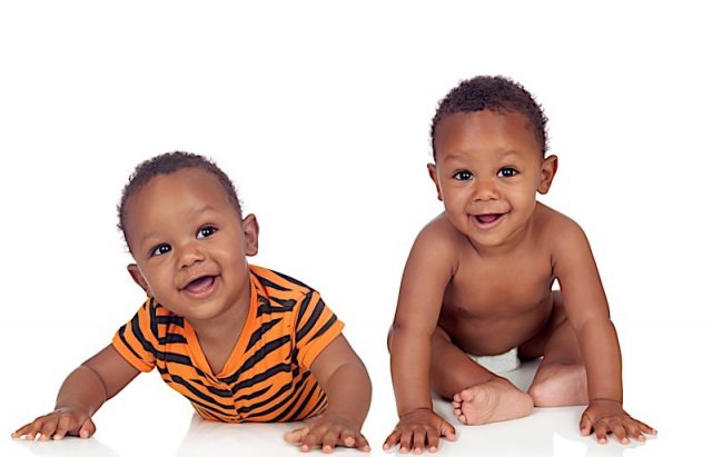 Two small identical black infants on white floor isolated Photo courtesy of BigStock/Gelpi