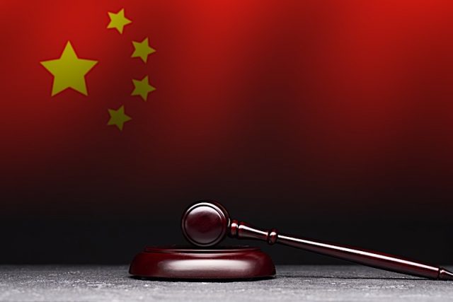 Judge's gavel on background of flag of China. Judge's gavel on background of flag of China.