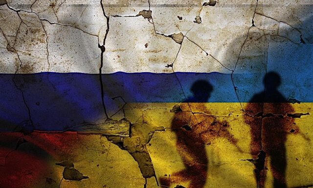 Russia Vs Ukraine Flag On Cracked Wall, Concept Of War Between Russia And Ukraine, Silhouette Of Sol Photo courtesy of BigStock/Isaiphoto