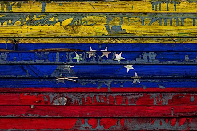 The National Flag Of Venezuela Is Painted On Uneven Boards. Country Symbol. Photo courtesy of BigStock/Everyonephoto