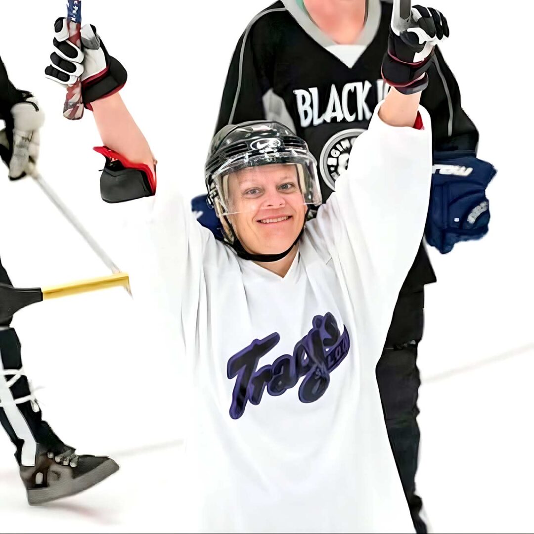 Woman playing hockey excited with arms in the air.