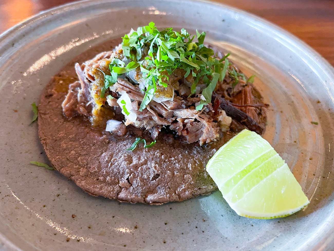 A plate with a single brisket taco.