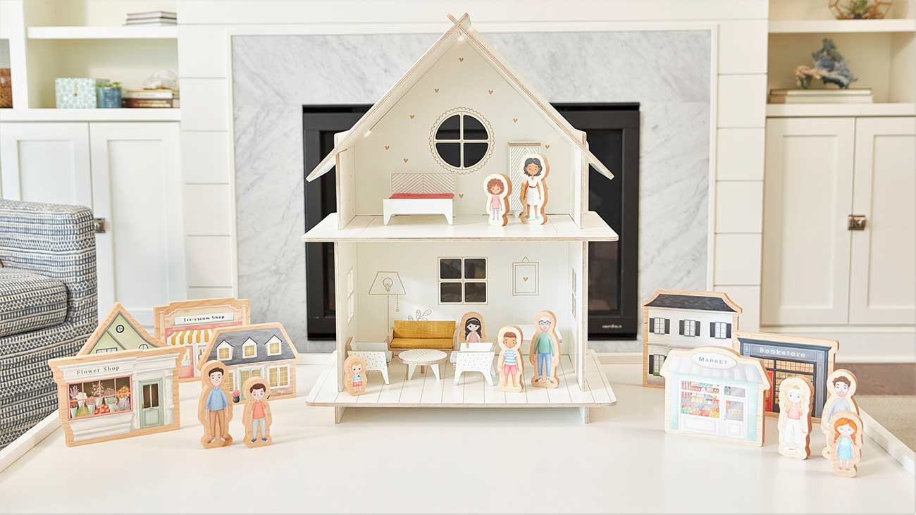 Dollhouse and dolls displayed on a table.