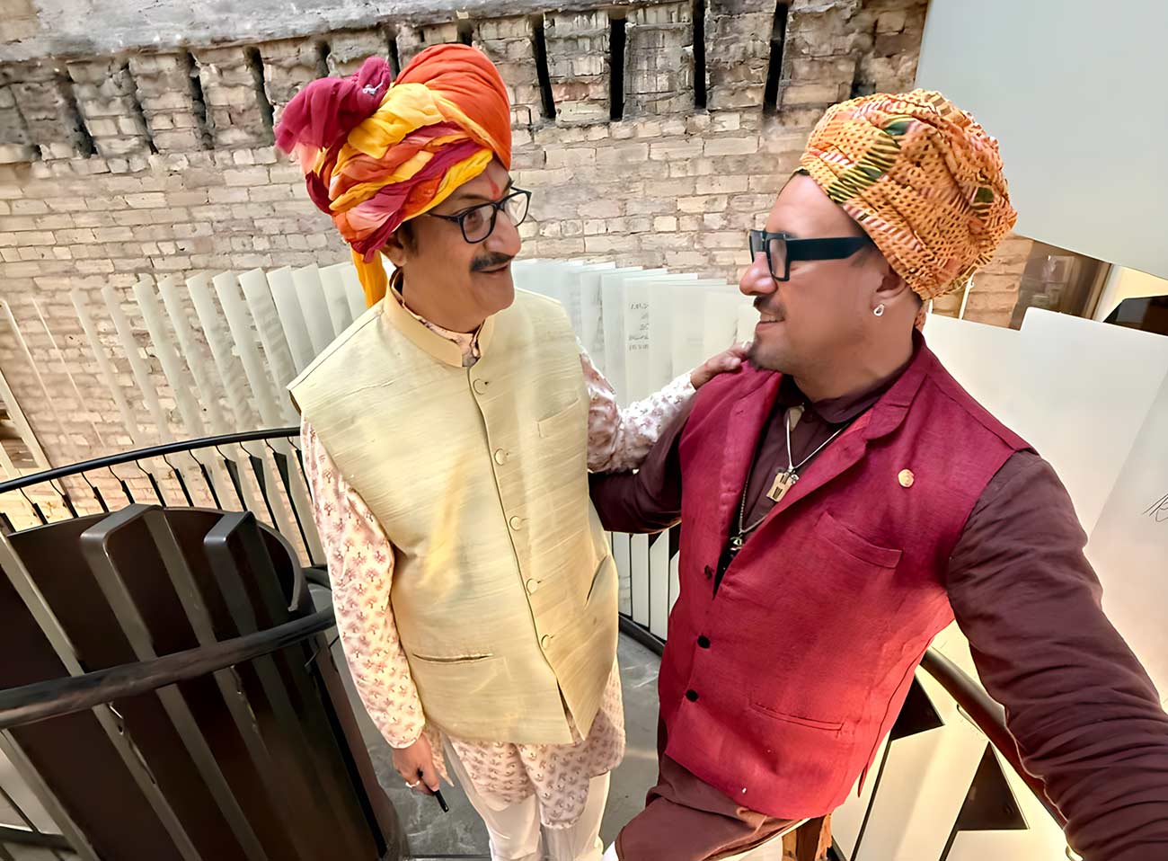 HRH Prince Manvendra Singh Gohil & HH Prince DeAndre taking a selfie photo on a staircase.