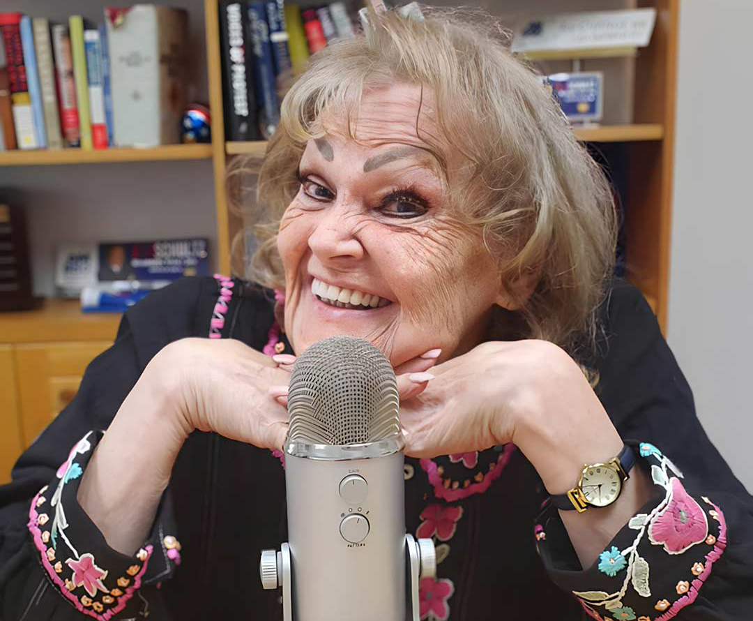 Julie Dafydd smiling behind her podcast microphone.