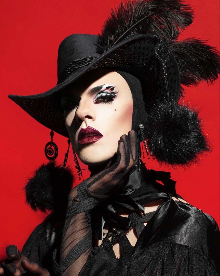 Utica wearing a black hat with pompoms.