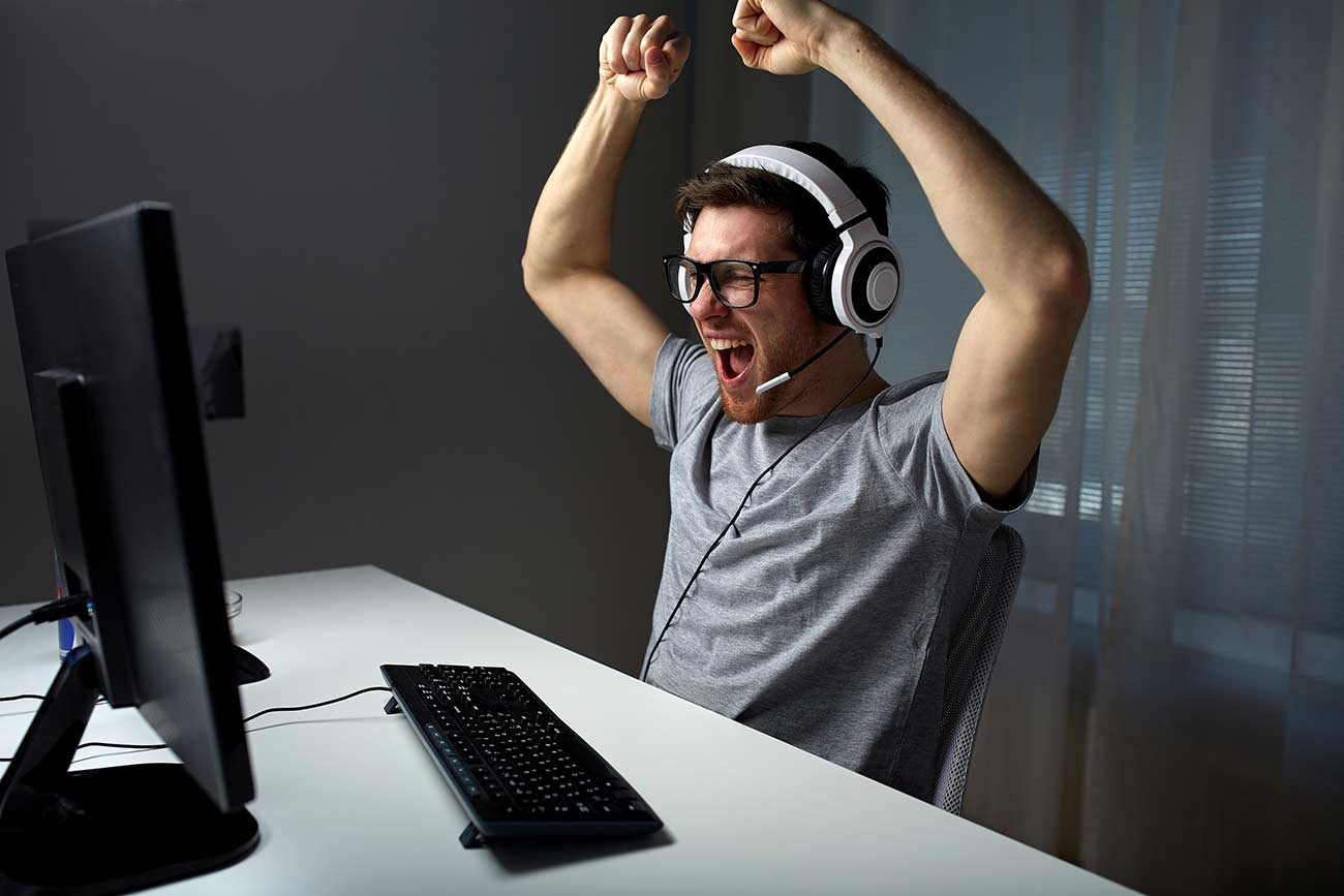 Young man playing and winning computer game.