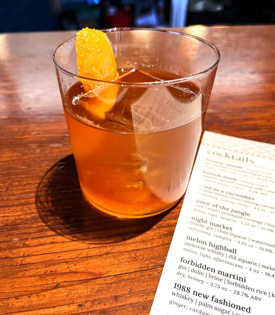 1988 Old Fashioned drink next to a cocktail menu.
