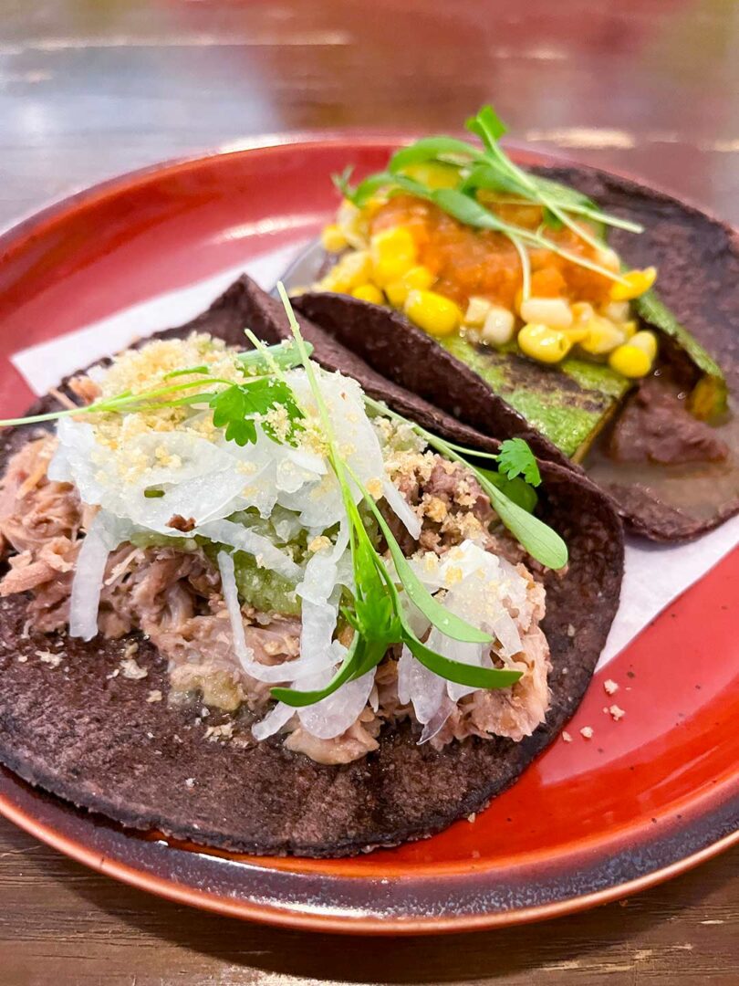 Small plate with Taco de Carnitas and Taco de Milpa.