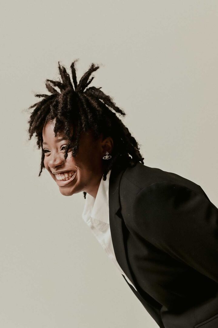 Shay Andrewin dressed in formal wear giving a large happy smile.