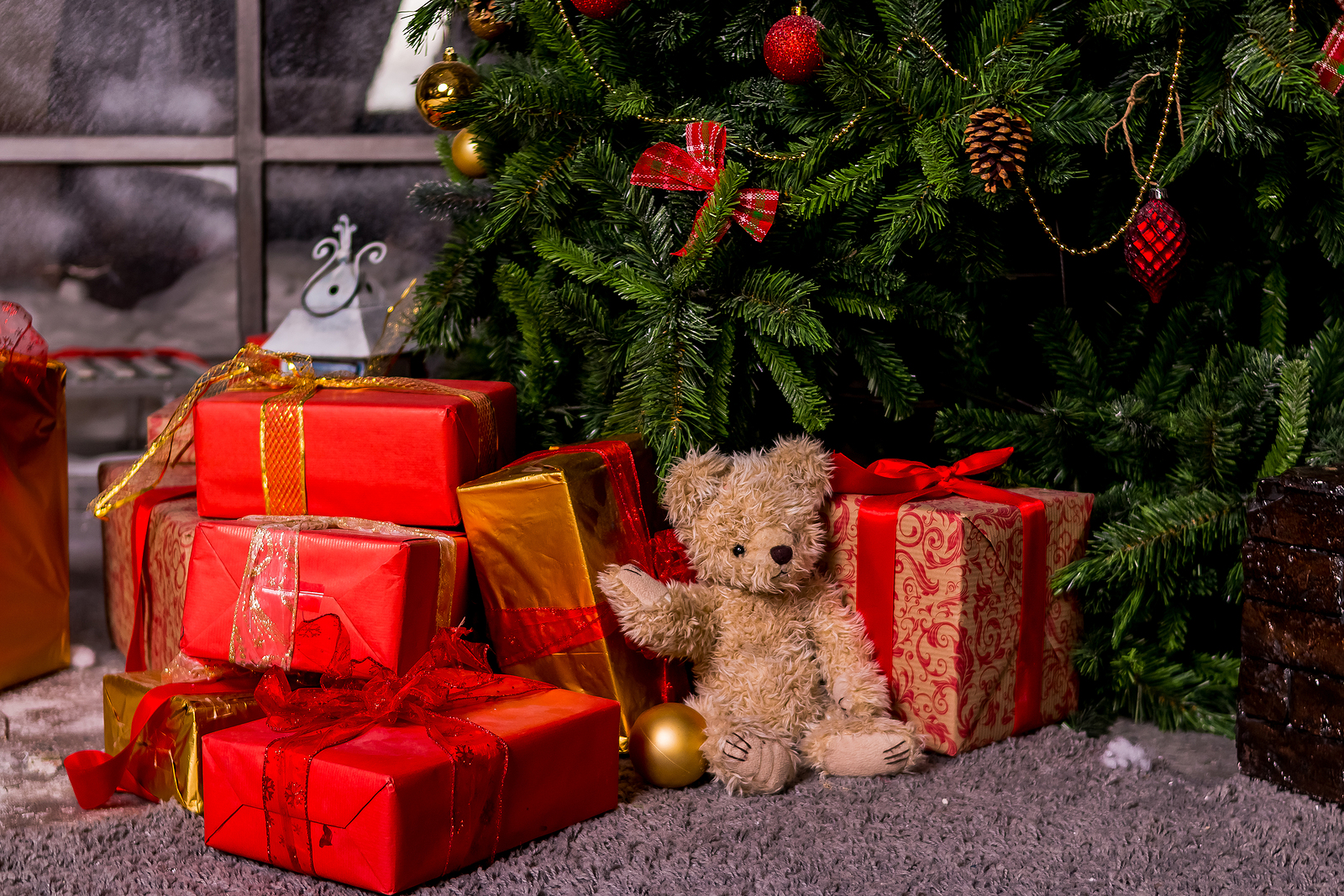 Christmas gifts under a tree in a cozy home setting.