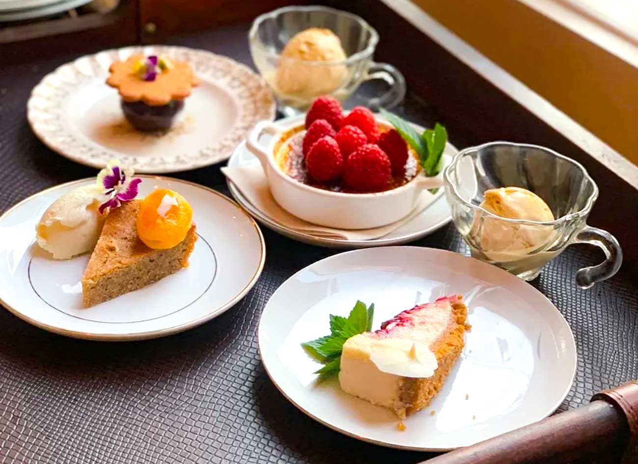 Tray featuring cheesecake, cake, cupcake, creme brulee, and small scoops of ice cream.