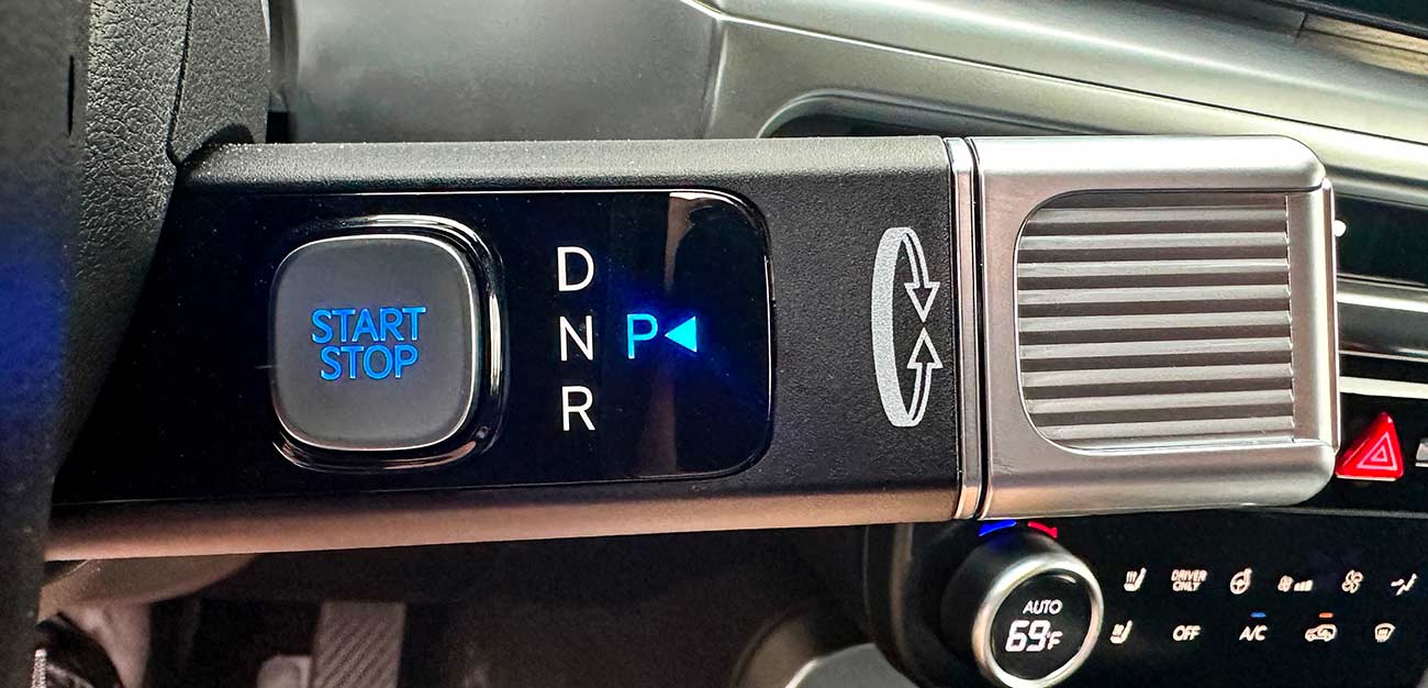 Close up of the start and stop button with the automatic car gears.