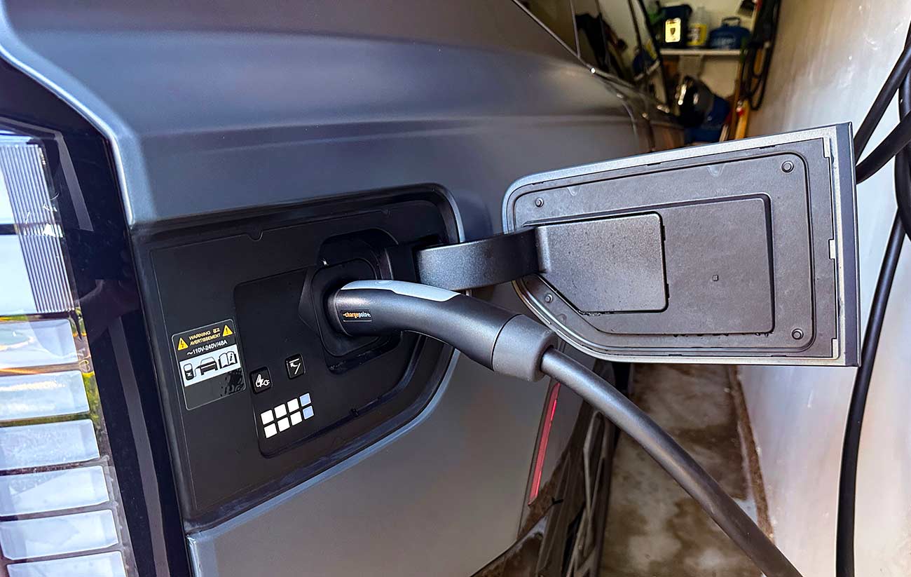 Close up of the vehicles charging port with the charger connected.
