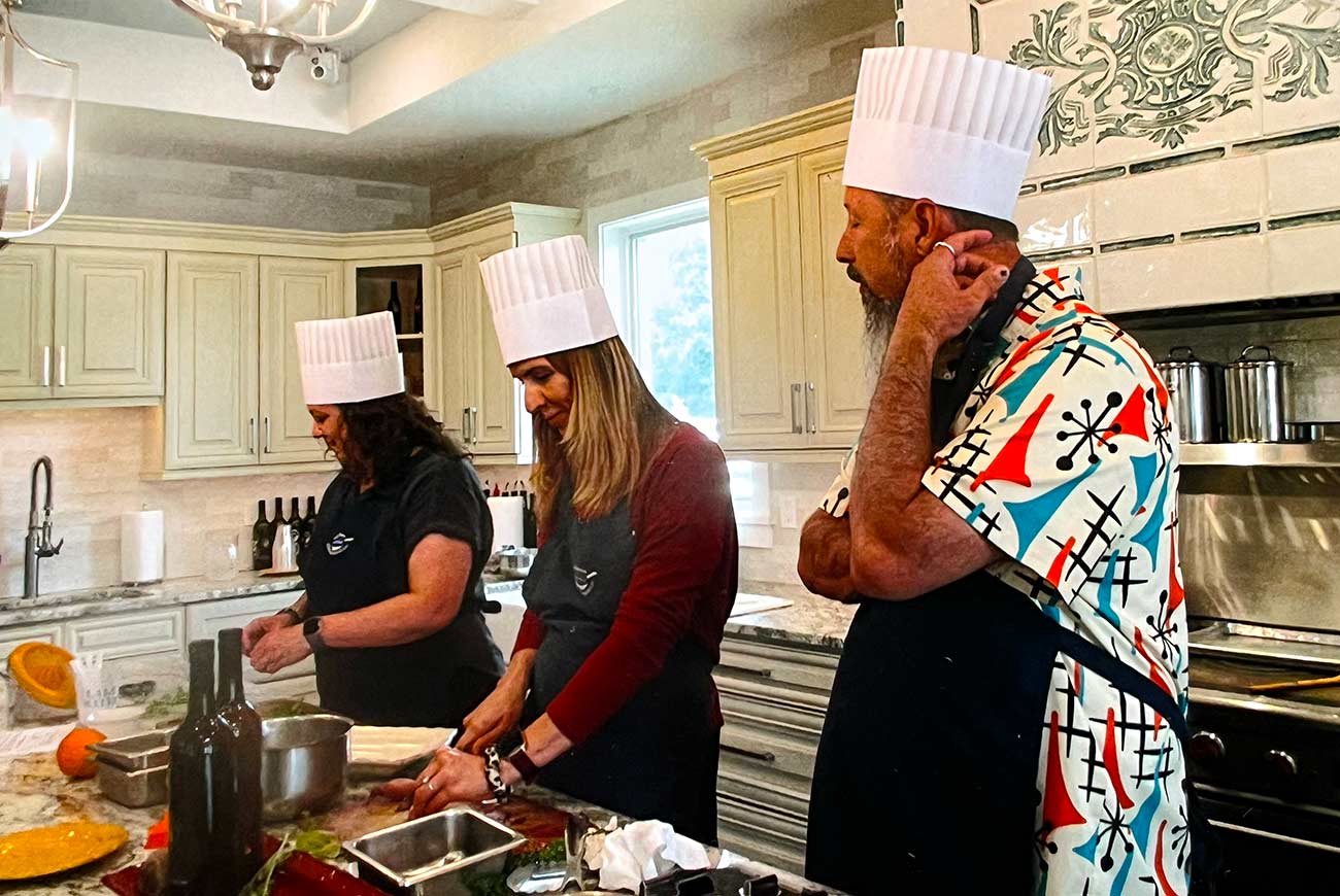 Three people learning to cook at the Lake Geneva School of Cooking.
