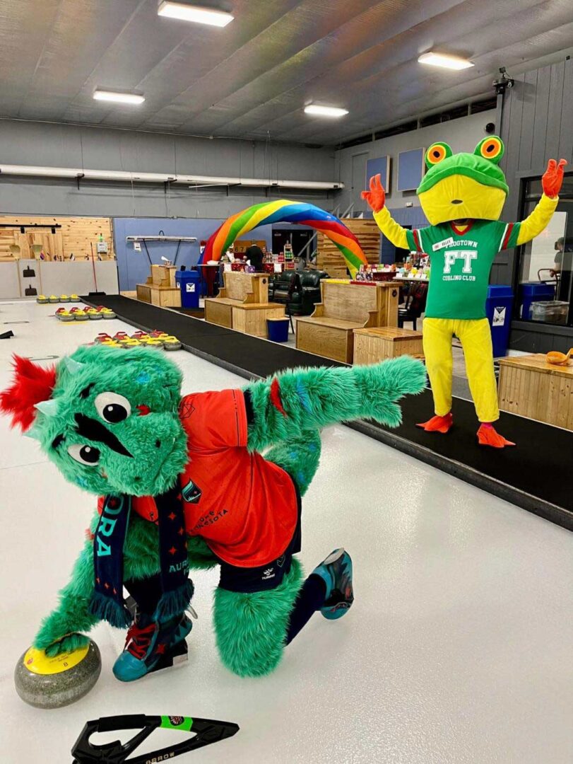Rory the Aurorasaurus mascot fooling around with Biff the Frog mascot.