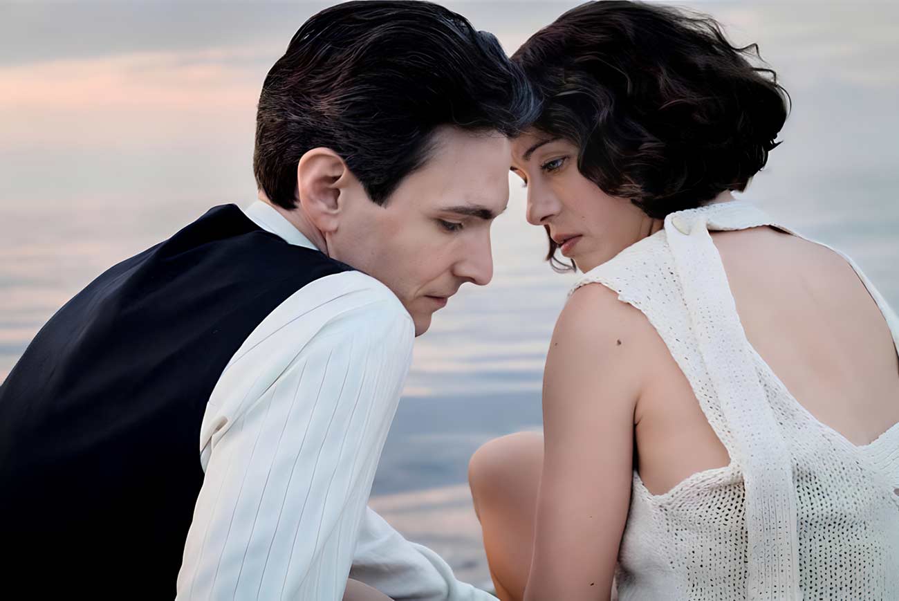 Young man and woman snuggling on the beach in the film The Glory of Life.