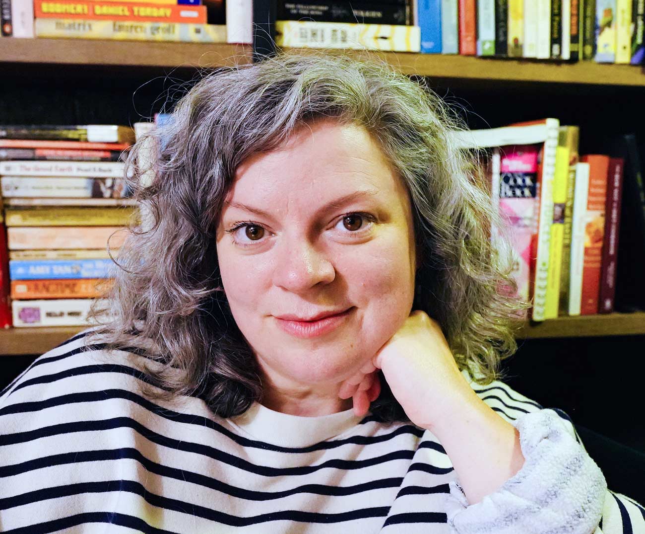 Headshot of book author Kelly Foster Lundquist with a bookshelf behind her.