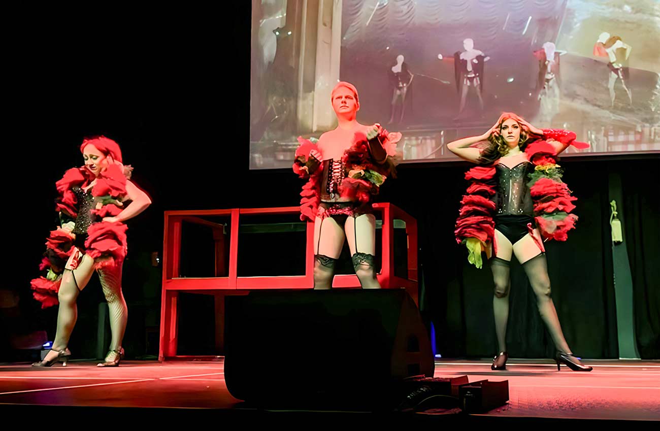 Three cast members of The Rocky Horror Picture Show on stage.