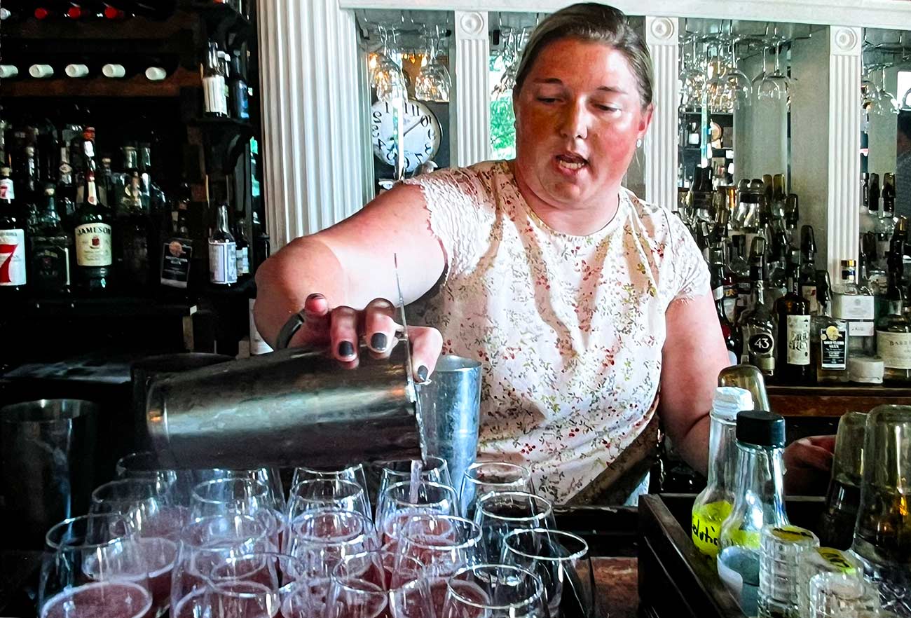 Woman pouring an elite cocktail at The Apothecary Bar.