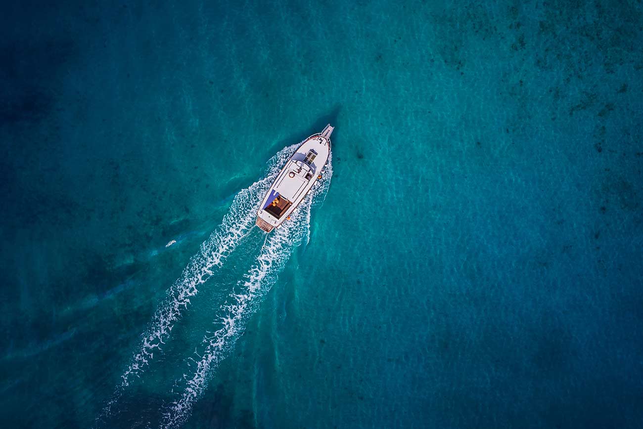 Vintage wooden boat in coral sea.