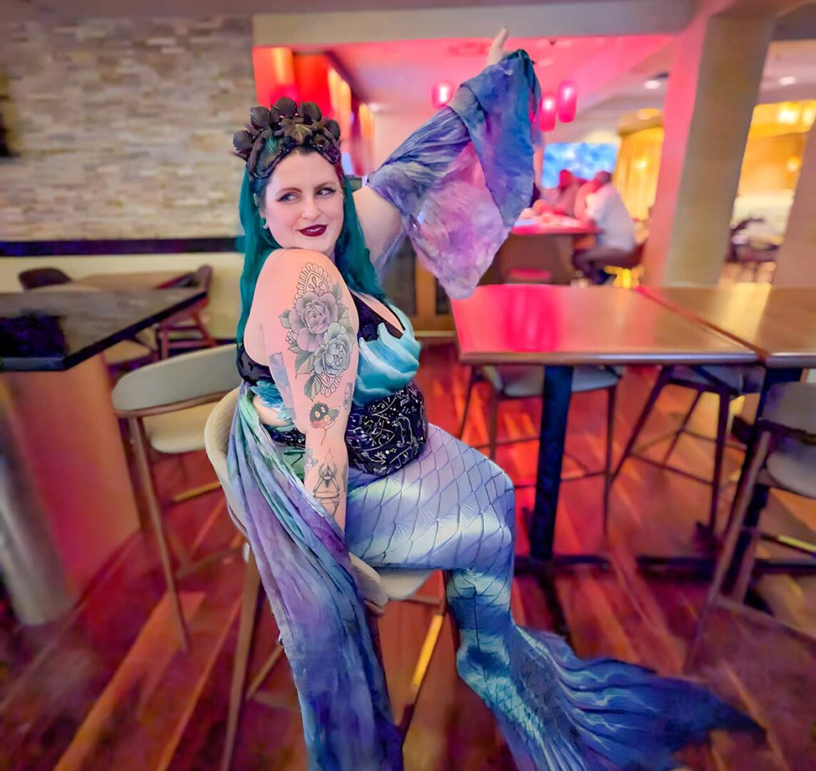 Rachel wearing her blue and purple mermaid costume inside a restaurant.