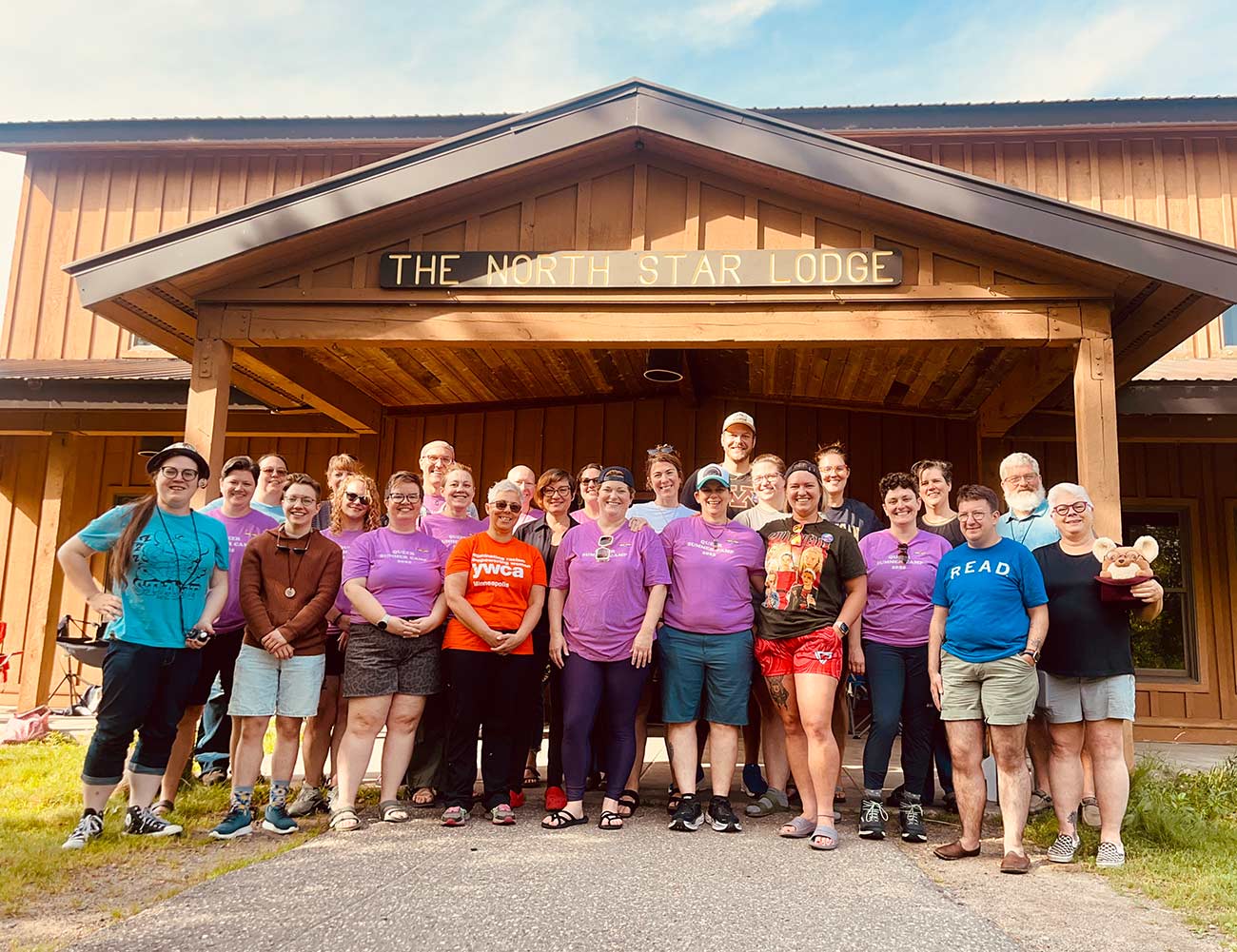 Queer Summer campers members pose for a photo in front of The North Star Lodge.
