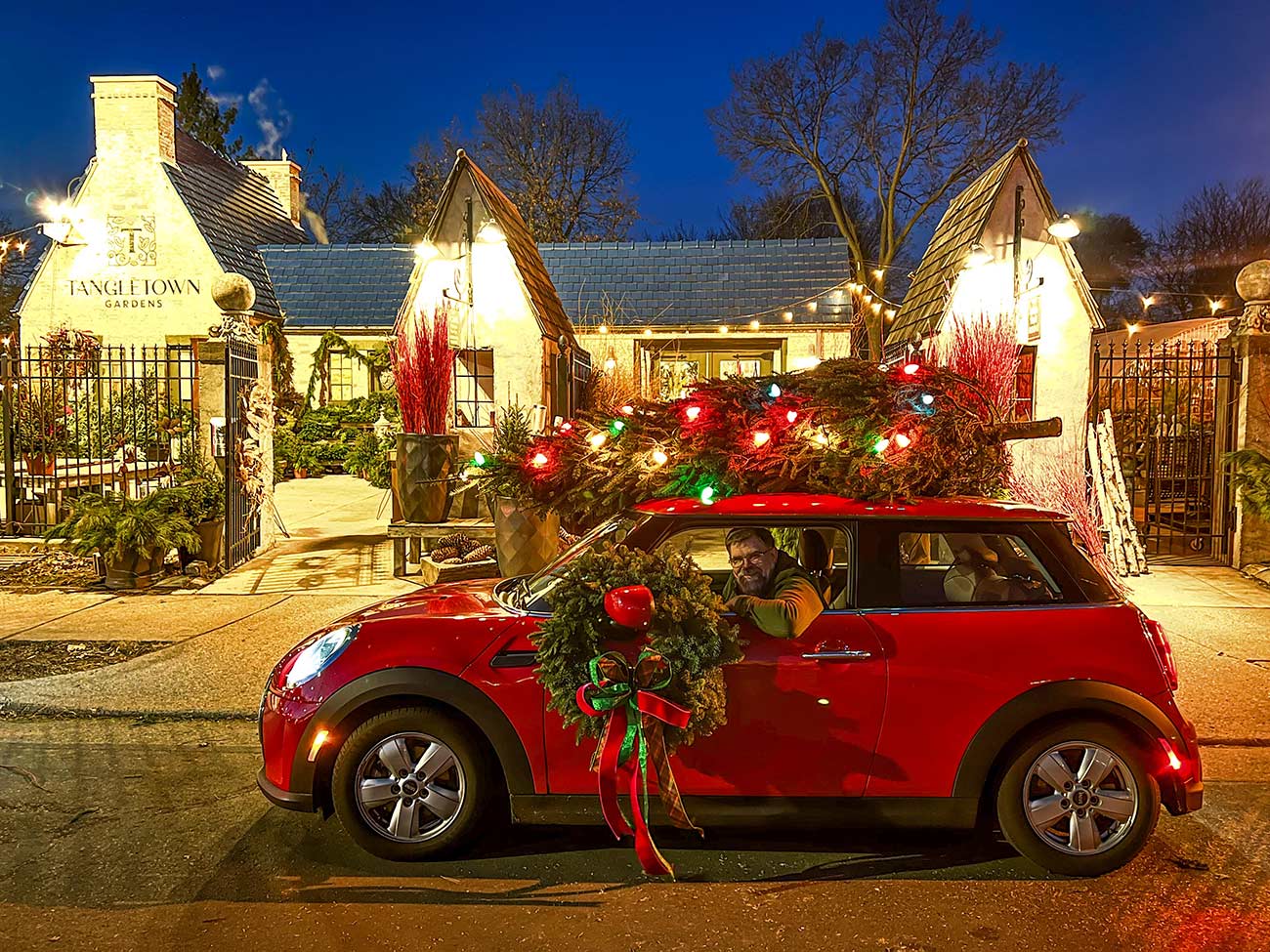Scott in his car with holiday decor in front of his business Tangletown Gardens.