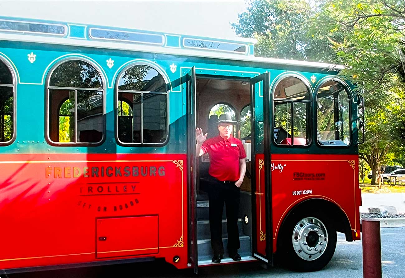Man standing an waving on the trolley tour of Fredericksburg, TX.