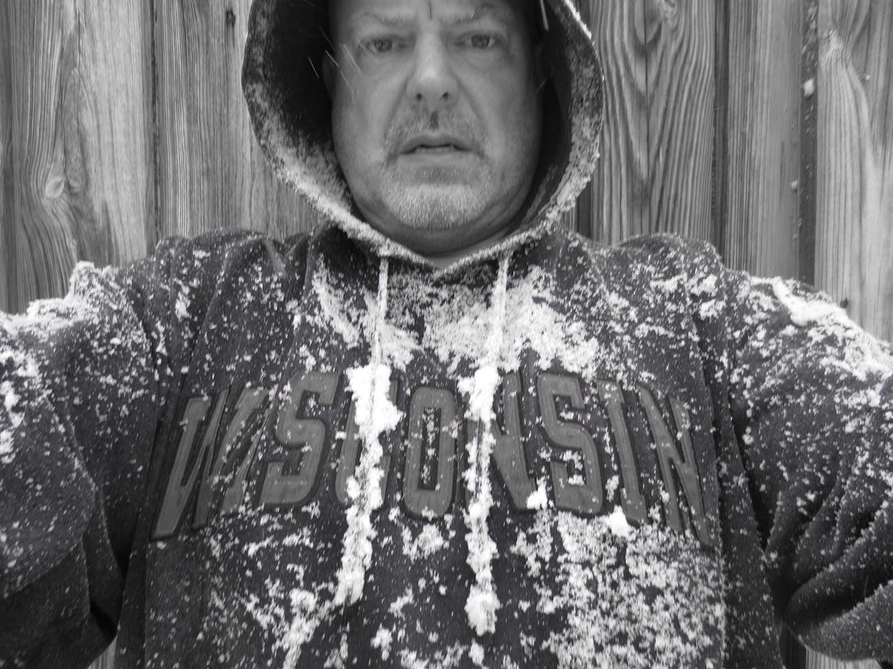 Black and white photo of Terrance Griep in a hoodie full of snow.