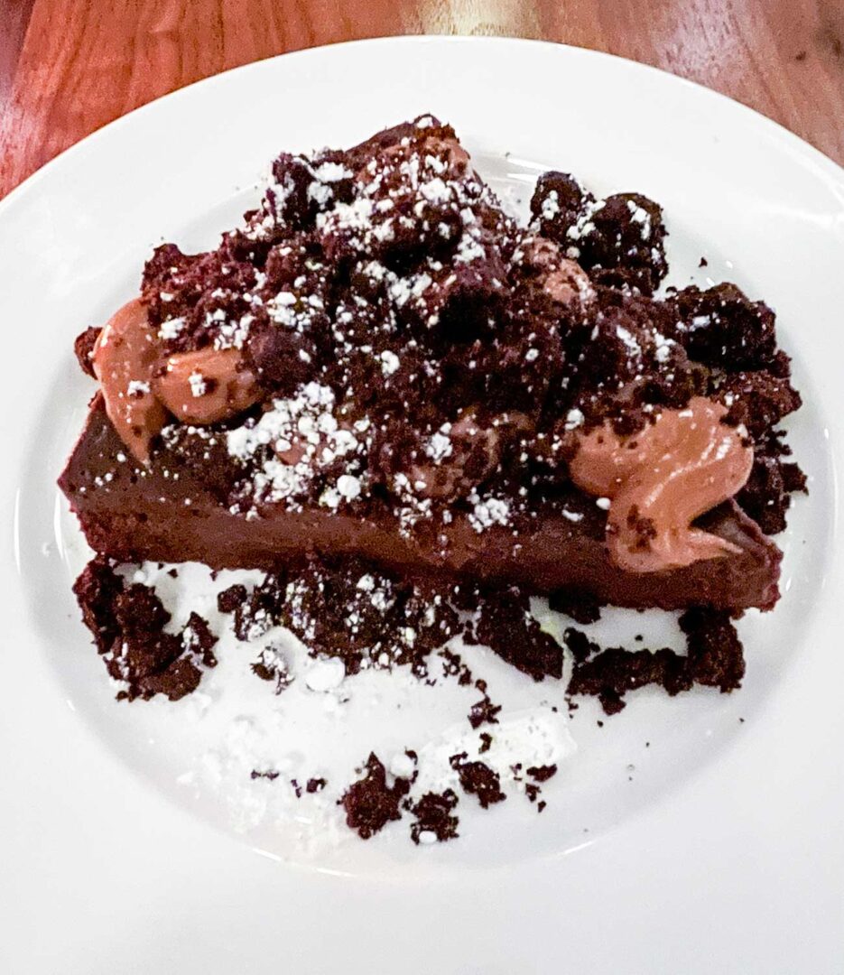 A slice of Flourless Chocolate Torte with chocolate crumble, gin and tonic mousse.