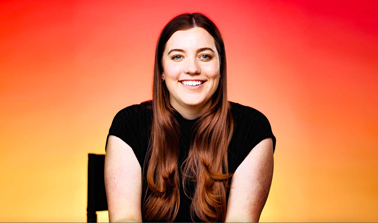 Headshot of Nicole Gress with orange and yellow background.