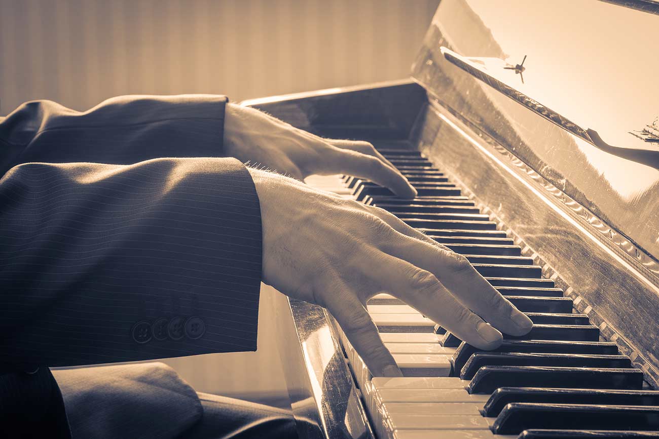 Retro style photo of a man's hands playing the piano.