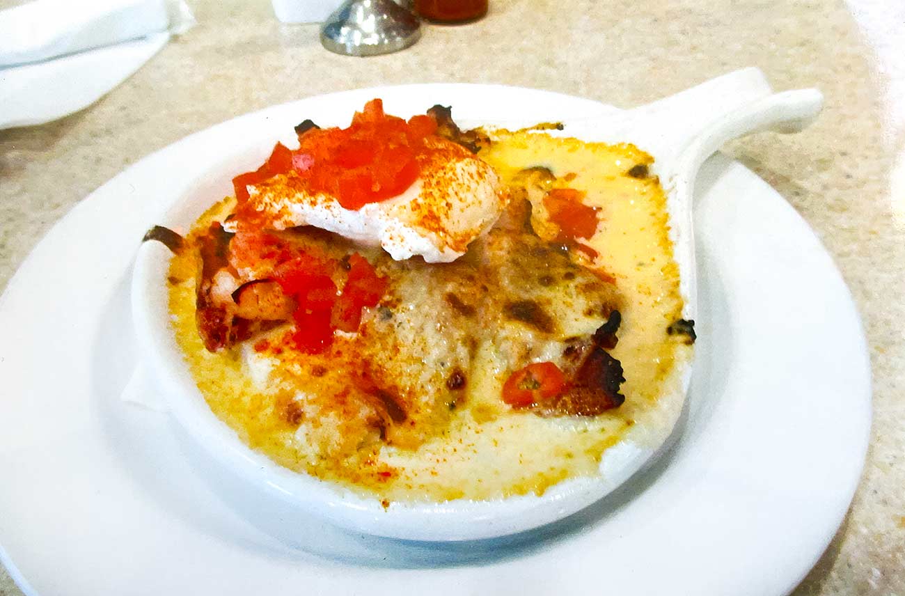 Plate with a small bowl featuring the Brown Hotel’s iconic Hot Brown sandwich.