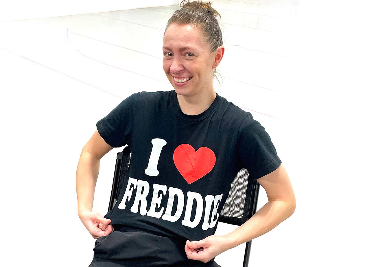 Woman sitting in a chair showing of her shirt that says I Love Freddie.