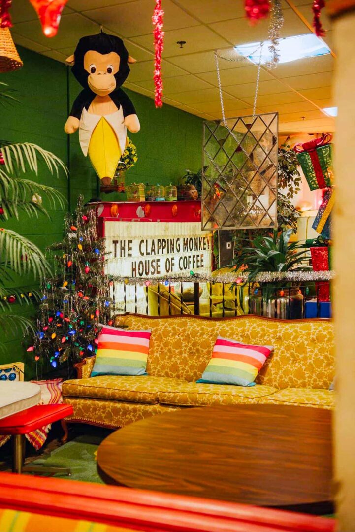 Interior shot of The Clapping Monkey Cafe with a vintage light up sign and a plush monkey coming out of a banana peel hanging from the ceiling.