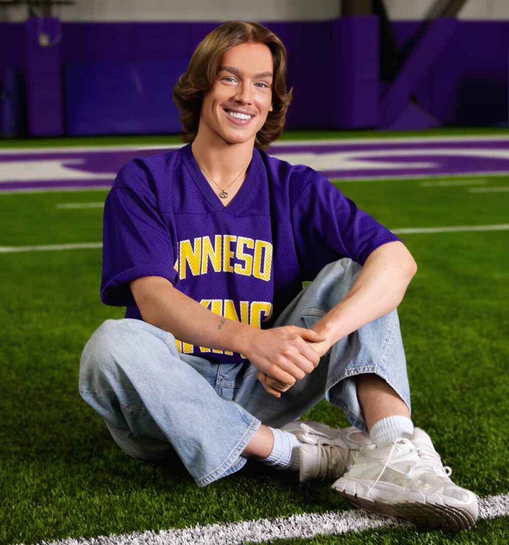 Minnesota Vikings Cheerleader Blaize Shiek sitting on the Vikvings training field smiling.