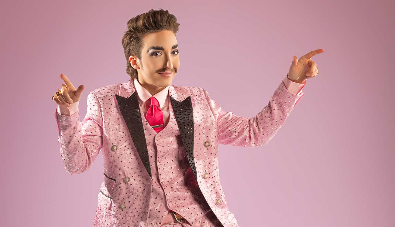 Promotional shot of drag king Dick Von Dyke in blinged pink suit.