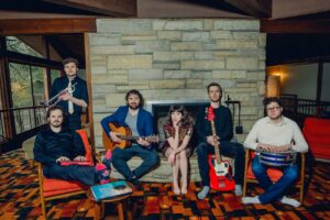Musician Leslie Vincent and her band pose in front of a fireplace.