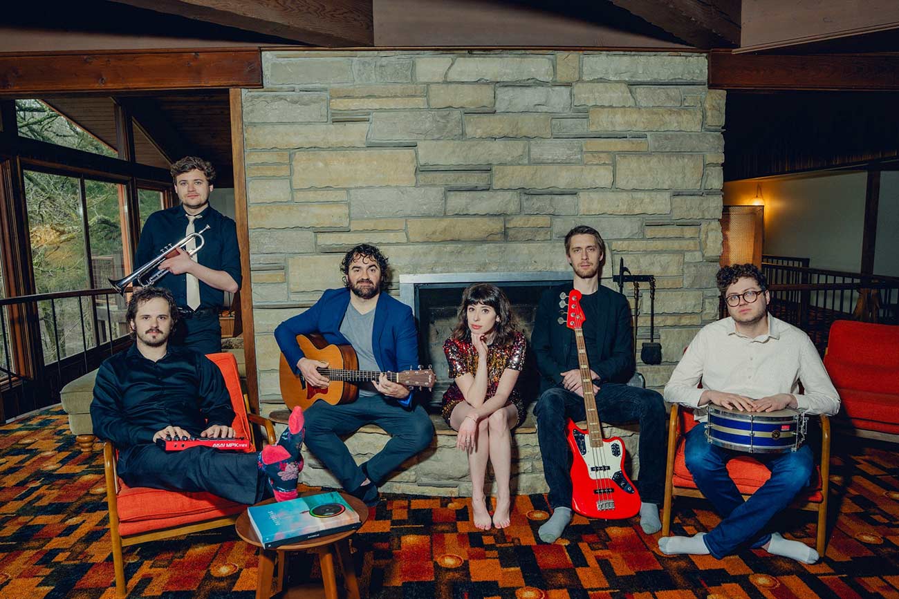 Musician Leslie Vincent and her band pose in front of a fireplace.