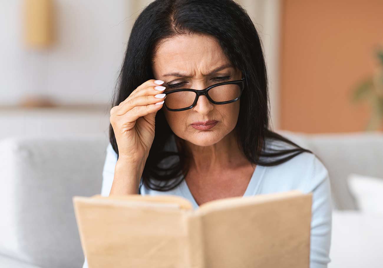Closeup portrait of confused mature woman squinting to see more clearly.