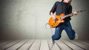 Guitarist with an electric guitar rock and roll jumping to music.